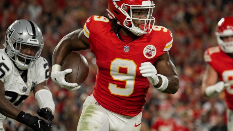 Kansas City Chiefs running back Kenneth Walker III carrying the football during a night game